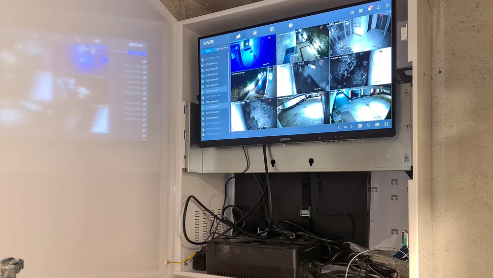 Intérieur résidentiel, technicien installant une caméra de surveillance fixée au plafond